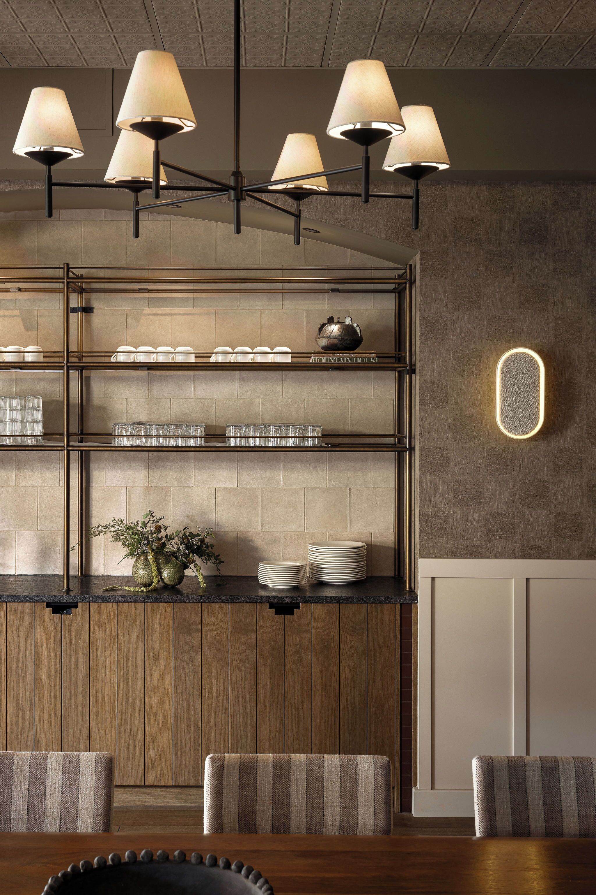 A modern kitchen with a wooden island, hanging pendant lights, and a built-in oven.