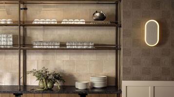 A modern kitchen with a wooden island, hanging pendant lights, and a built-in oven.