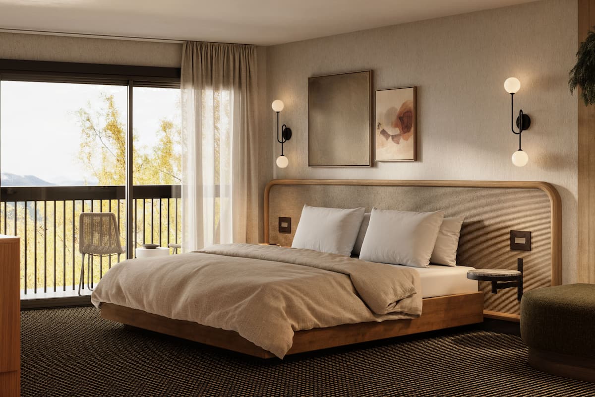 A bedroom with a large bed, a view of trees through a balcony, and a painting on the wall.