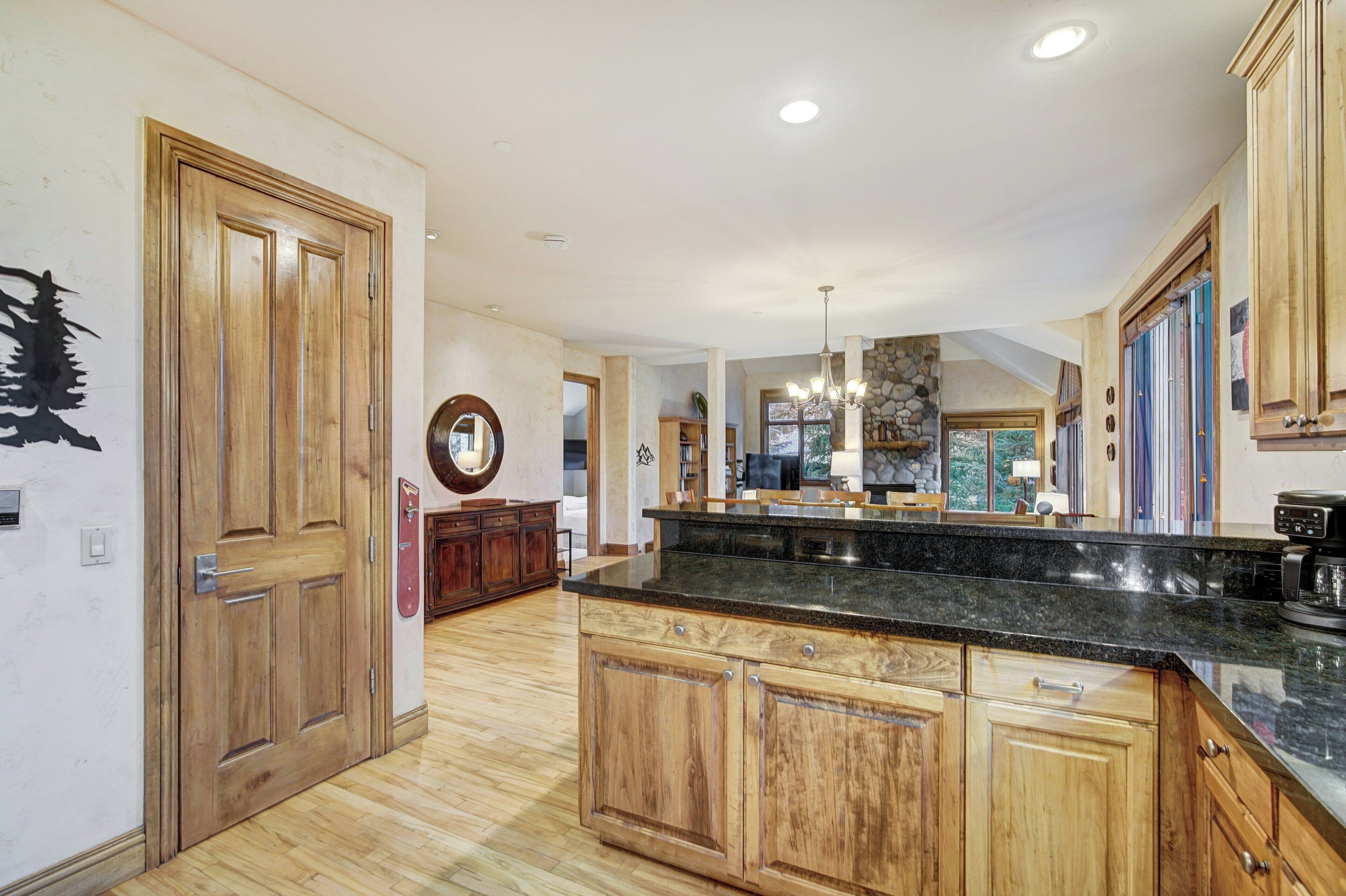 Una cocina amplia con armarios de madera, encimera de granito y una pared decorativa de piedra.