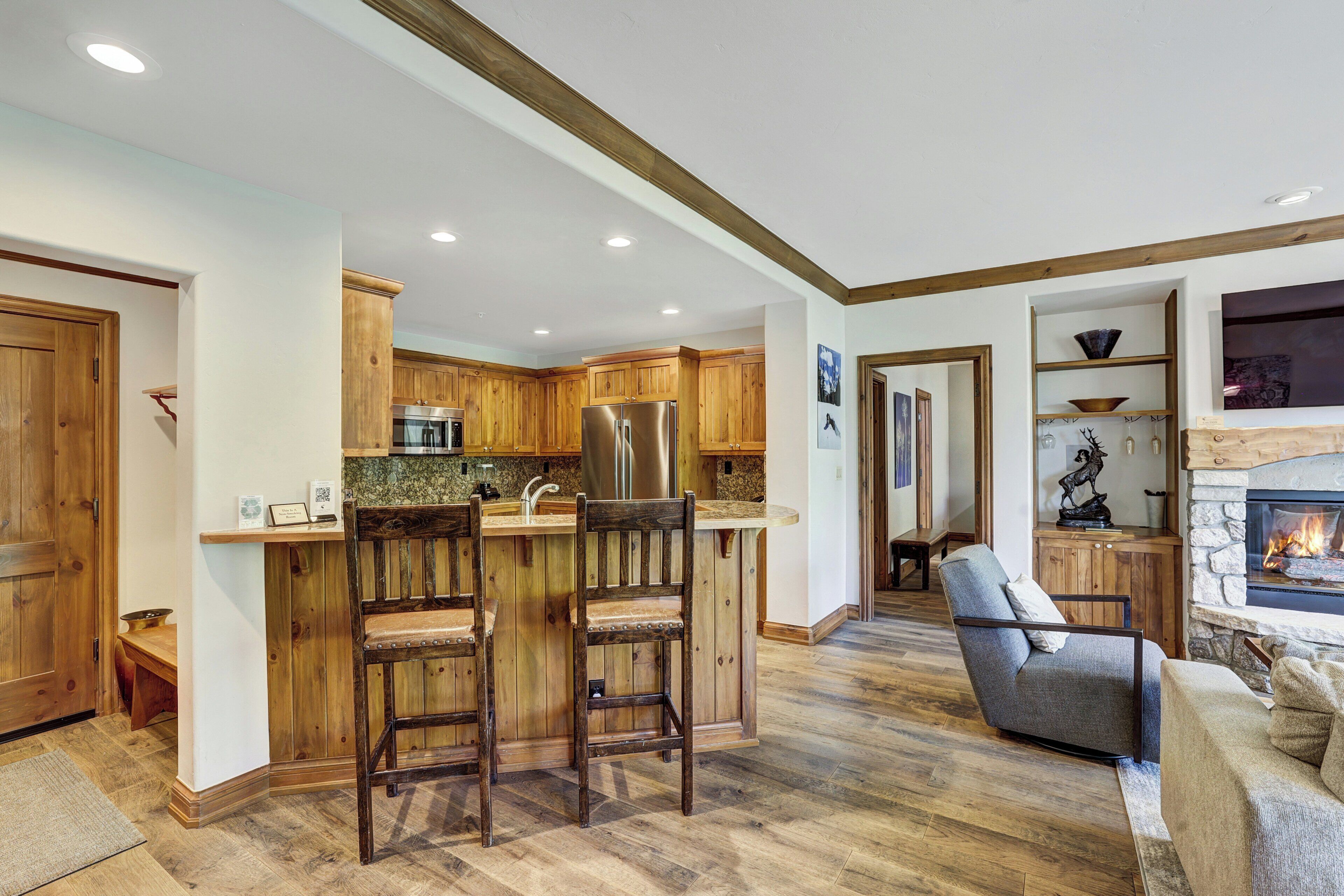 Une cuisine moderne avec des meubles en bois, un îlot central et une cheminée en pierre.