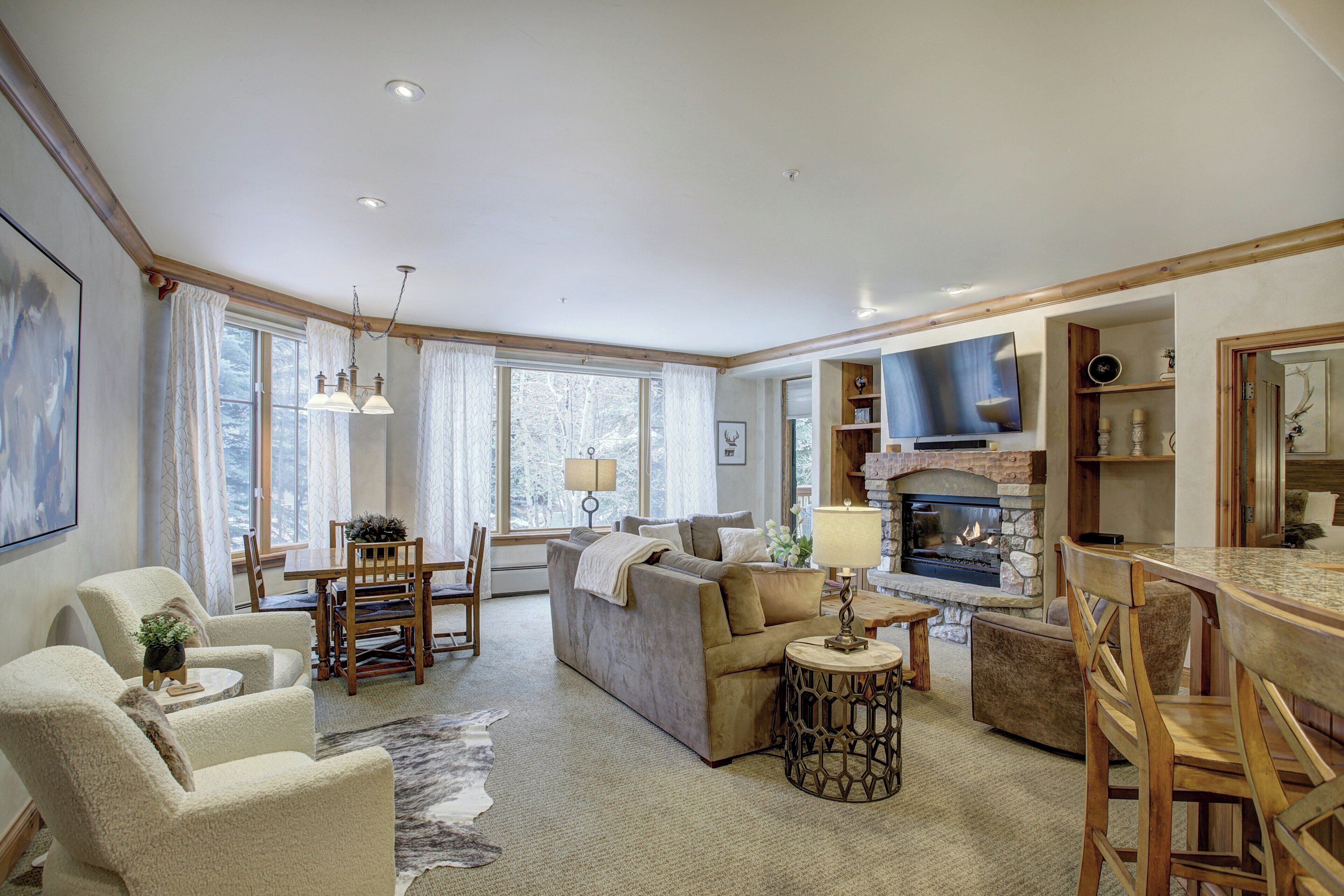 A cozy living room with a fireplace, comfortable seating, and a dining area.