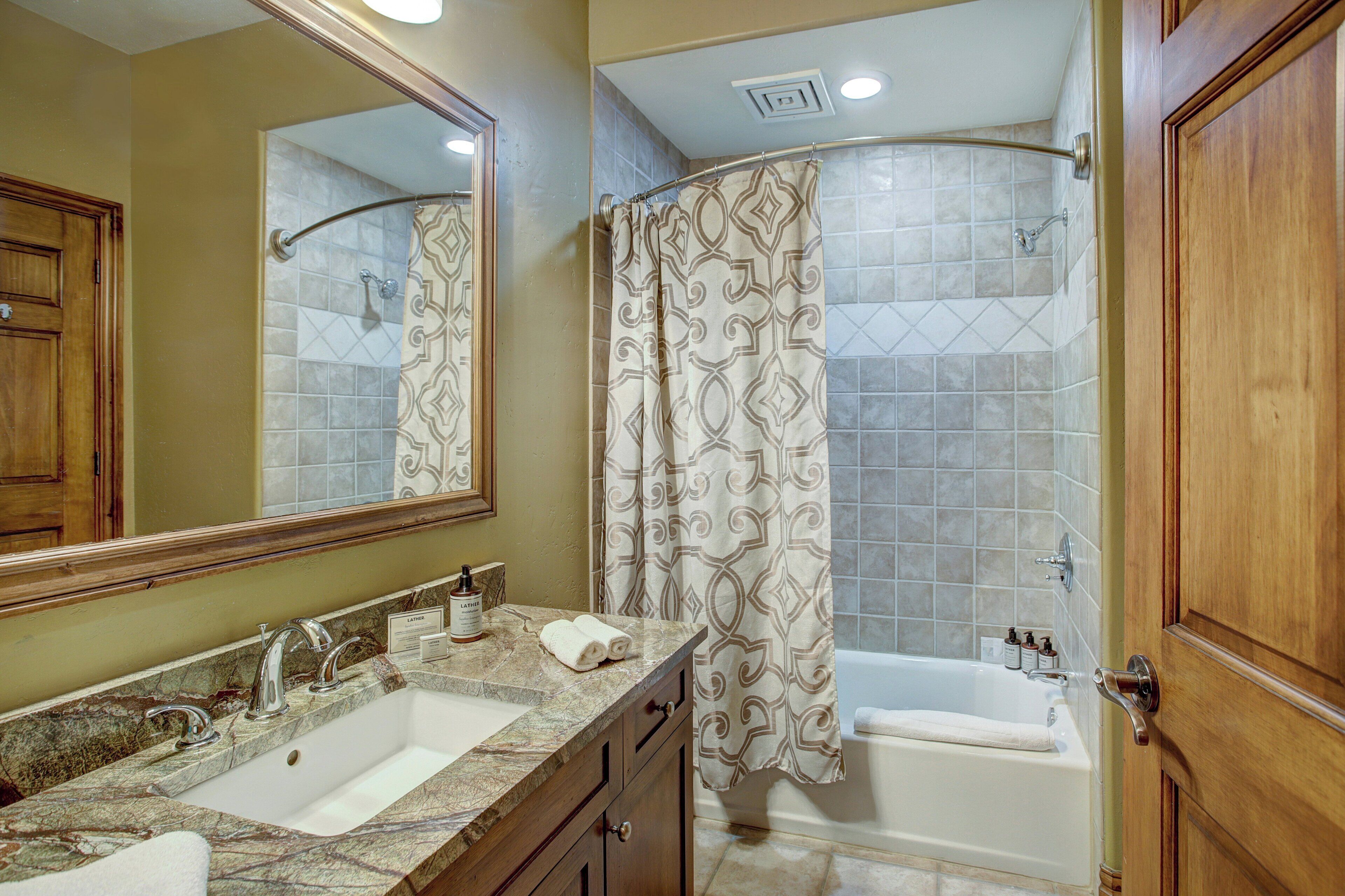 Un bagno con doppio lavabo, doccia e vasca da bagno.
