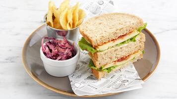A plate with a sandwich, fries, and coleslaw.