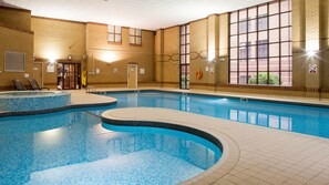 Swim laps in a spacious pool surrounded by a tiled deck and lounge chairs.