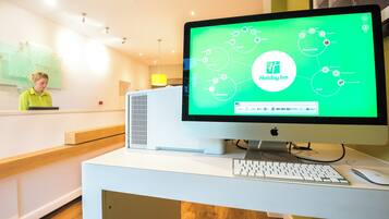 A desktop computer with a green screen displaying a Holiday Inn logo and various icons.