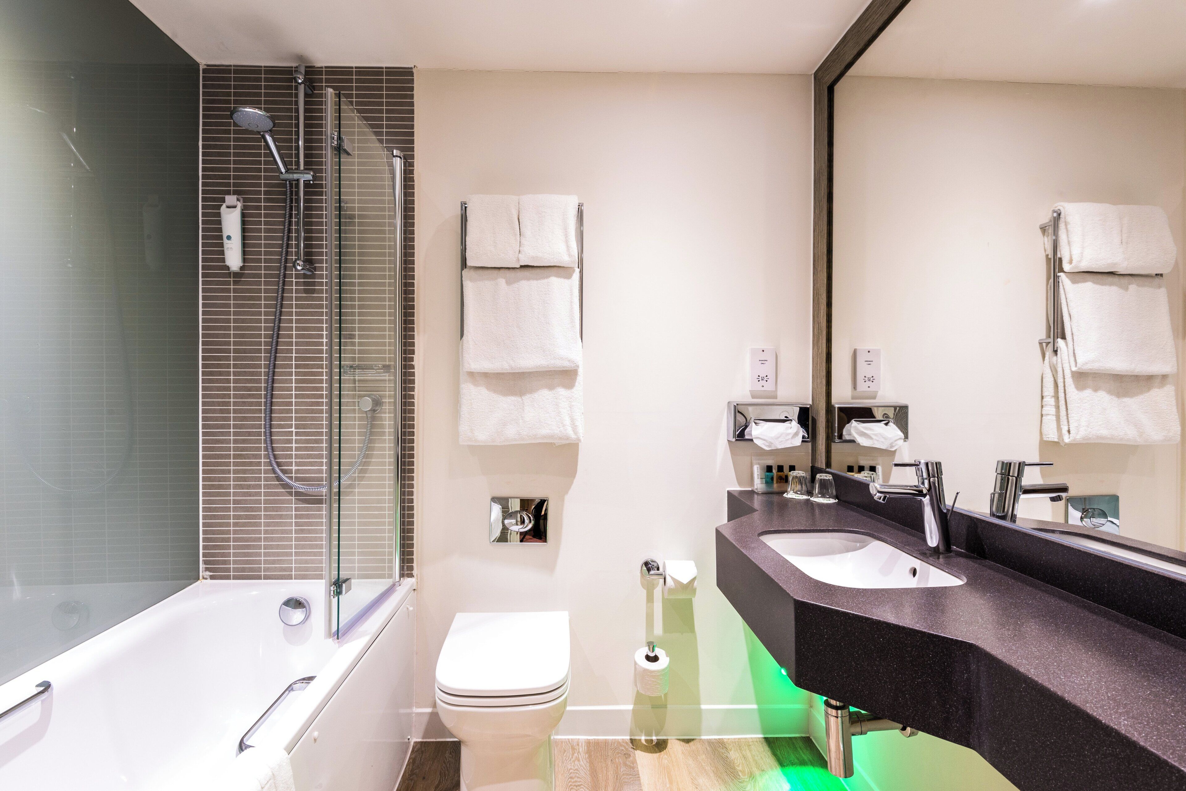 A modern bathroom with a bathtub, a toilet, a sink, and a shower.