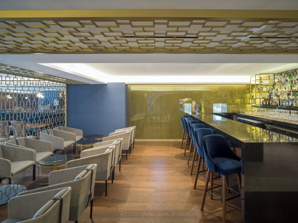 A bar area with seating, a bar counter, and a patterned ceiling. - Grand Fiesta Americana Chapultepec (Mexico City)