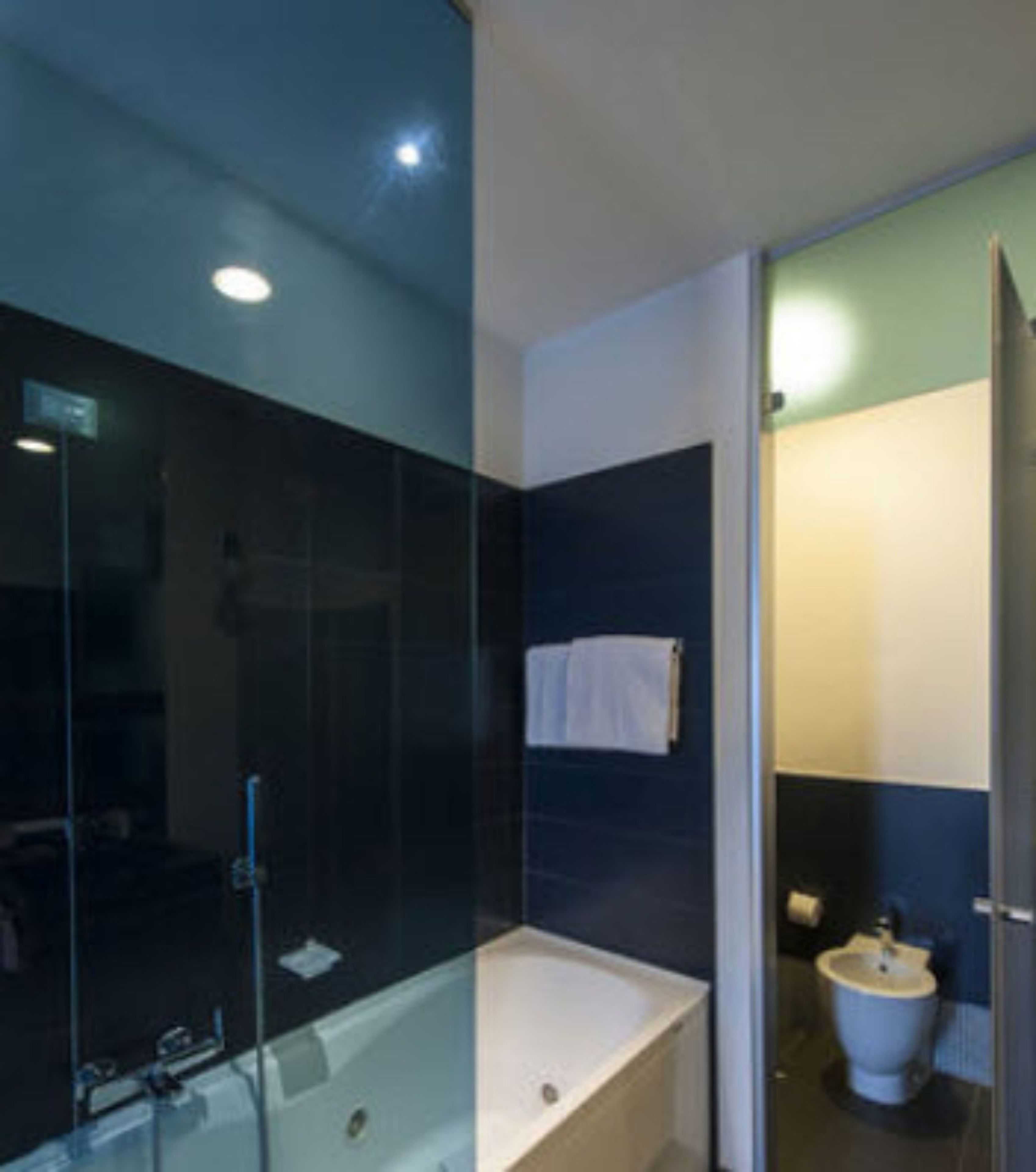 A modern bathroom with a glass-enclosed shower, a standalone bathtub, and a toilet.