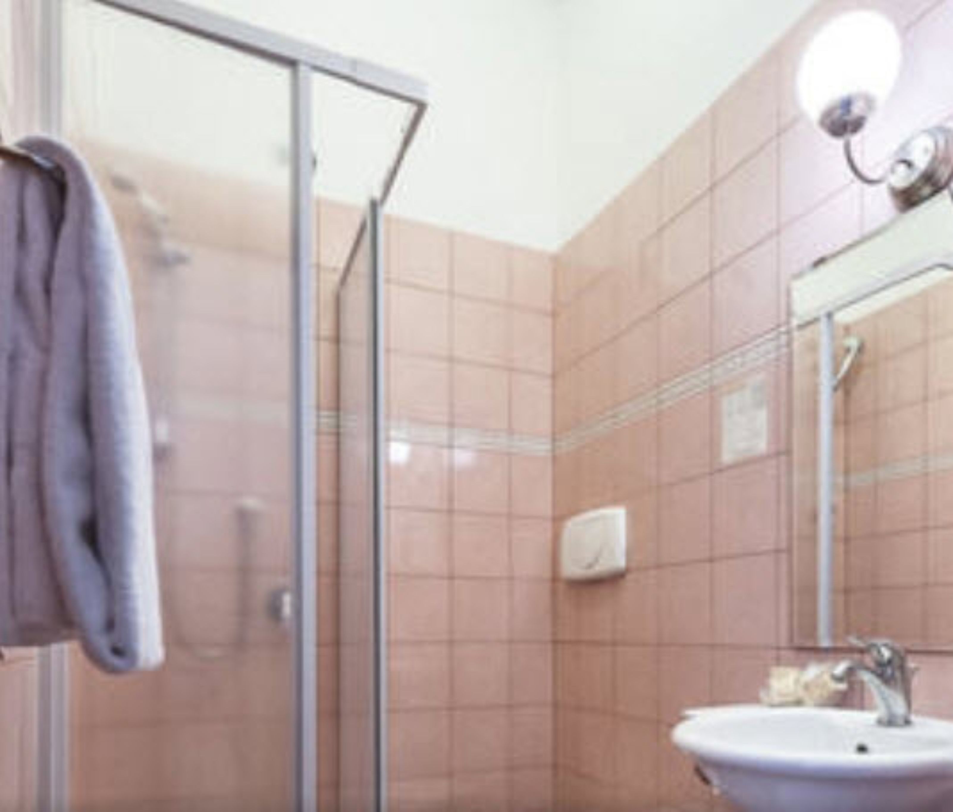 Une salle de bain avec une douche à parois de verre, un lavabo et un miroir.