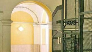 Eine Treppe mit Metallgeländer und einer gelb-weißen Wand.