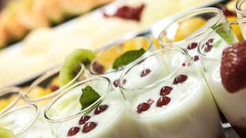 Ein Dessertbuffet mit verschiedenen joghurtbasierten Getränken mit Früchten und einer Auswahl weiterer Desserts im Hintergrund.