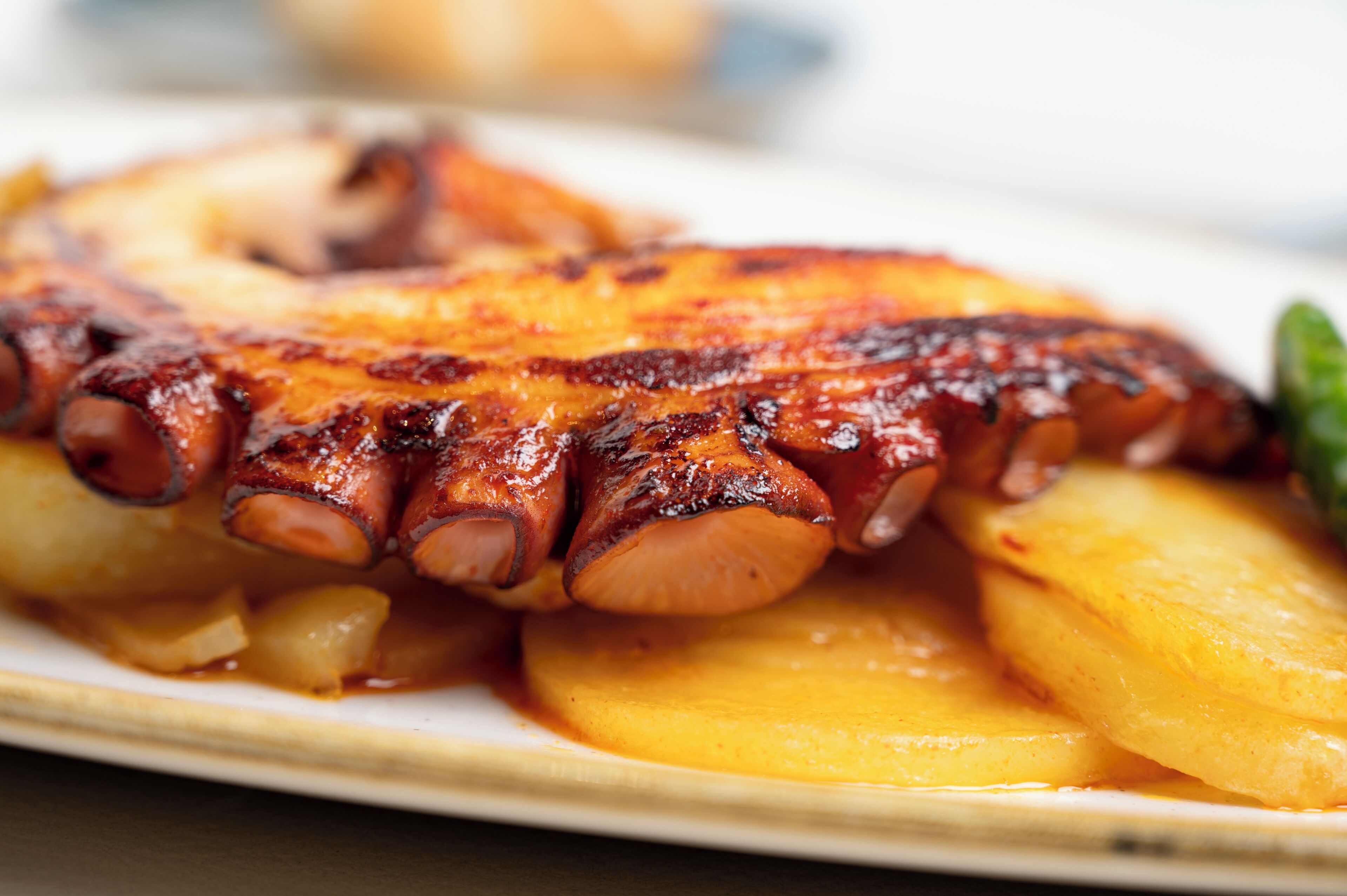 A plate of grilled octopus with potatoes.