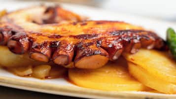A plate of grilled octopus with potatoes.
