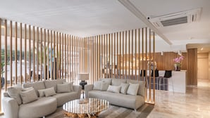 Una sala moderna con un sofá modular, una mesa de centro de vidrio y un tapete a rayas.