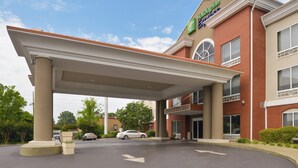Holiday Inn Express -hotelli, jossa on katettu pysäköintialue, tiiliverhous ja avoin taivas.