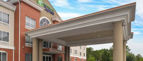 A Holiday Inn Express building with a covered entrance and a brick facade.
