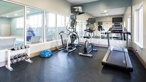 A gym with treadmills, elliptical machines, and a rowing machine. There are dumbbells on a rack and a blue exercise ball. - Holiday Inn Express & Suites Chattanooga (East Ridge) by IHG (Chattanooga)
