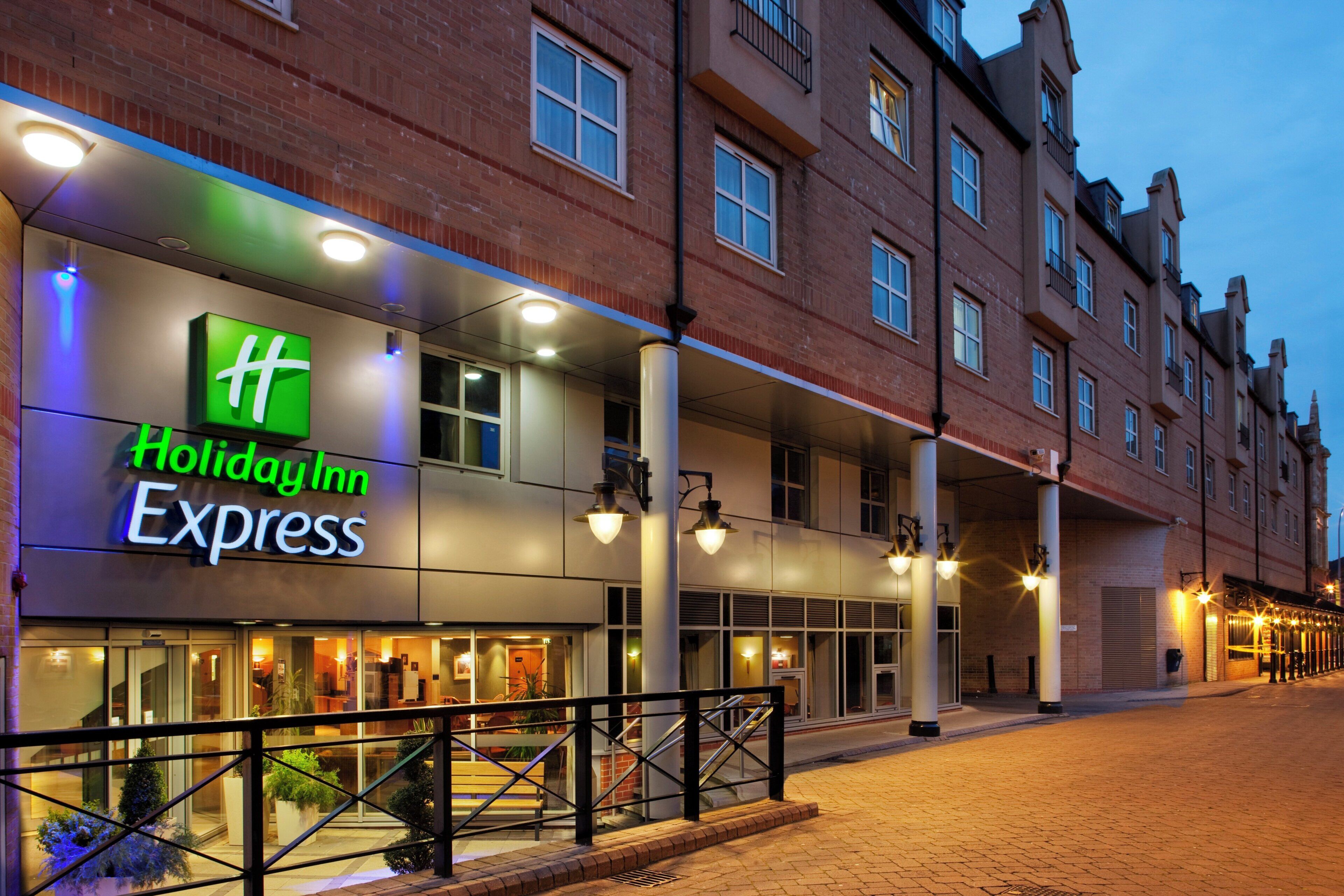 A Holiday Inn Express building with a brick facade, large windows, and a visible entrance.