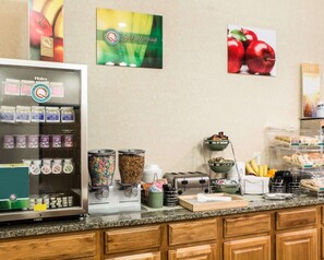 A breakfast bar with cereal, hot beverages, and a toaster.