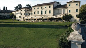 A large building with a courtyard, outdoor seating area, and a statue.