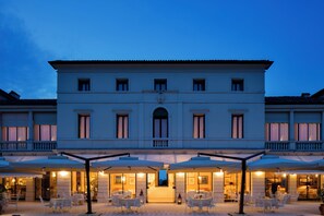 A large, elegant building with a central entrance, multiple balconies, and outdoor seating areas with umbrellas. - Villa Michelangelo Vicenza – Starhotels Collezione (Arcugnano)
