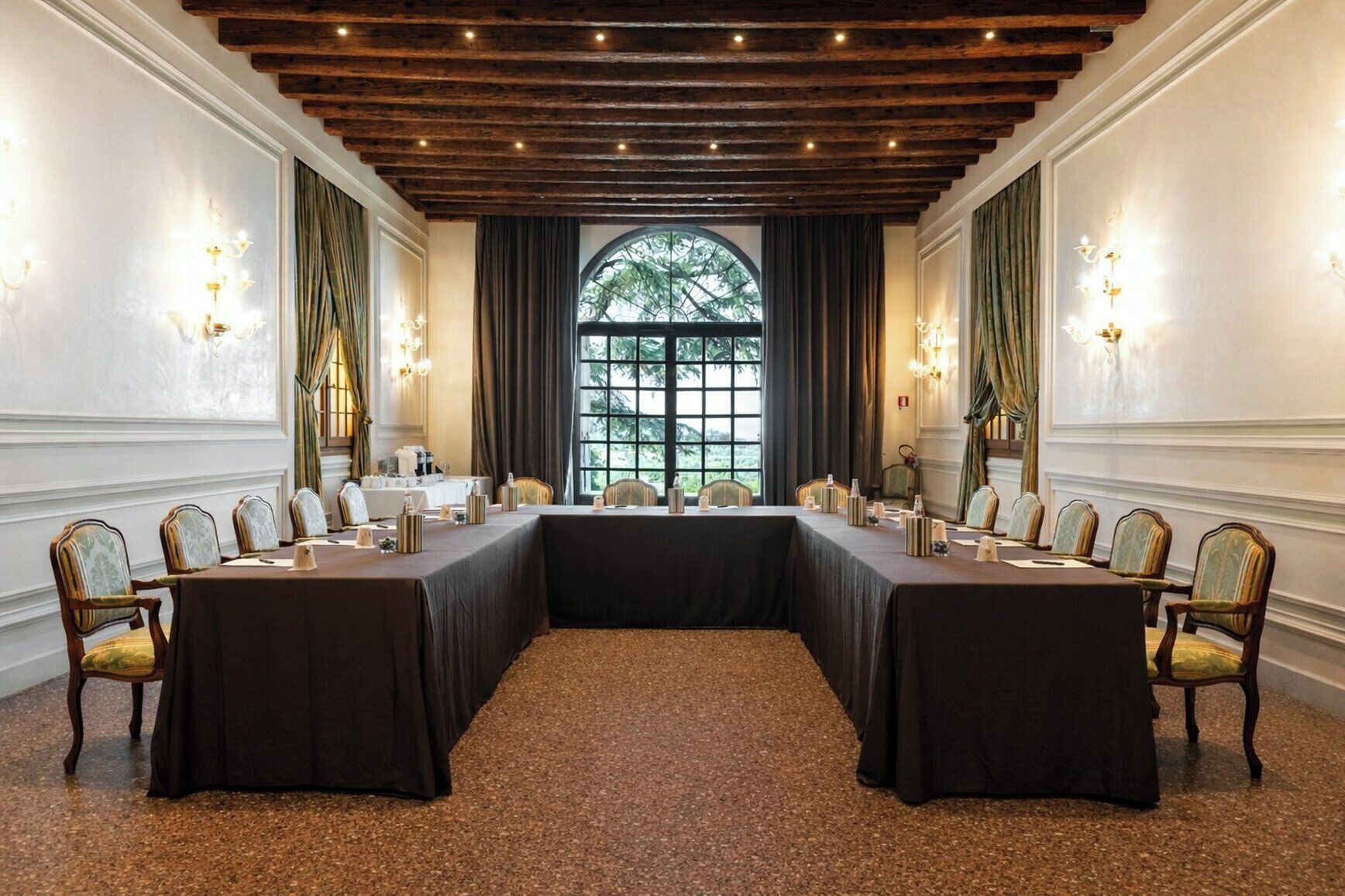 A conference room with a long table, chairs, and a large window with a view.