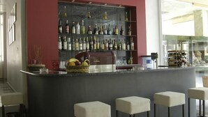 A bar area with a marble countertop, a fruit basket, and a wine rack with various bottles.