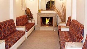 A living room with patterned sofas, a fireplace, and a mirror on the wall.