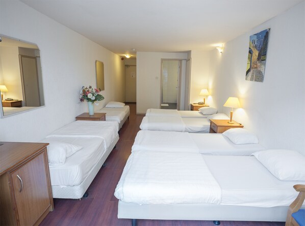 Habitación familiar, varias camas | Caja fuerte, wifi gratis, ropa de cama
