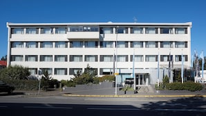 A multi-story hotel with a symmetrical facade, large windows, and a central entrance with steps.