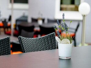 Een eettafel met een witte kop met een plantje en een glas.