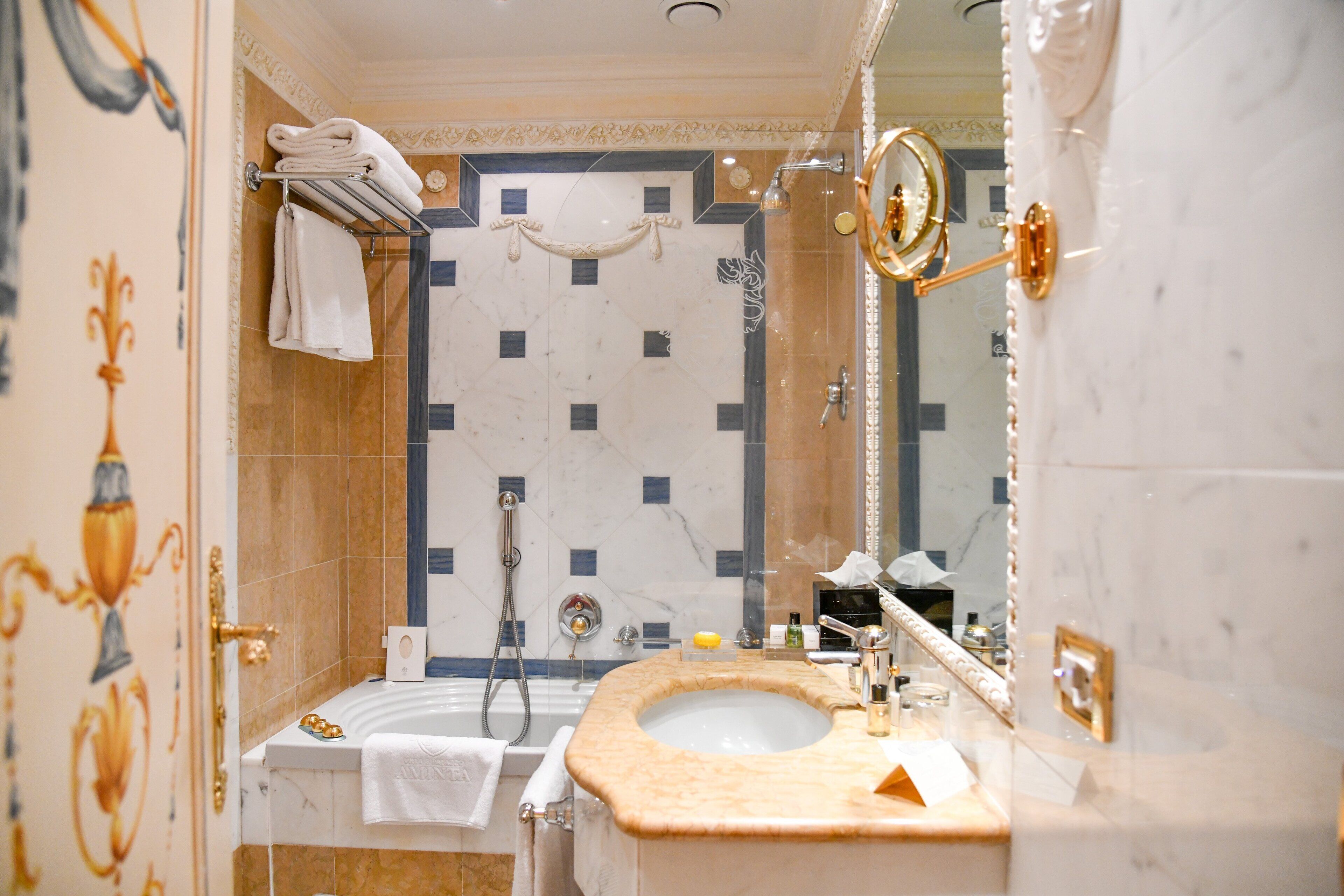 Ein Badezimmer mit Marmorwaschbecken, einer Badewanne und einer Dusche.