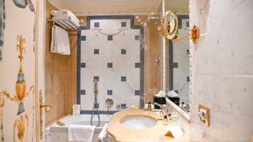 Ein Badezimmer mit Marmorwaschbecken, einer Badewanne und einer Dusche.