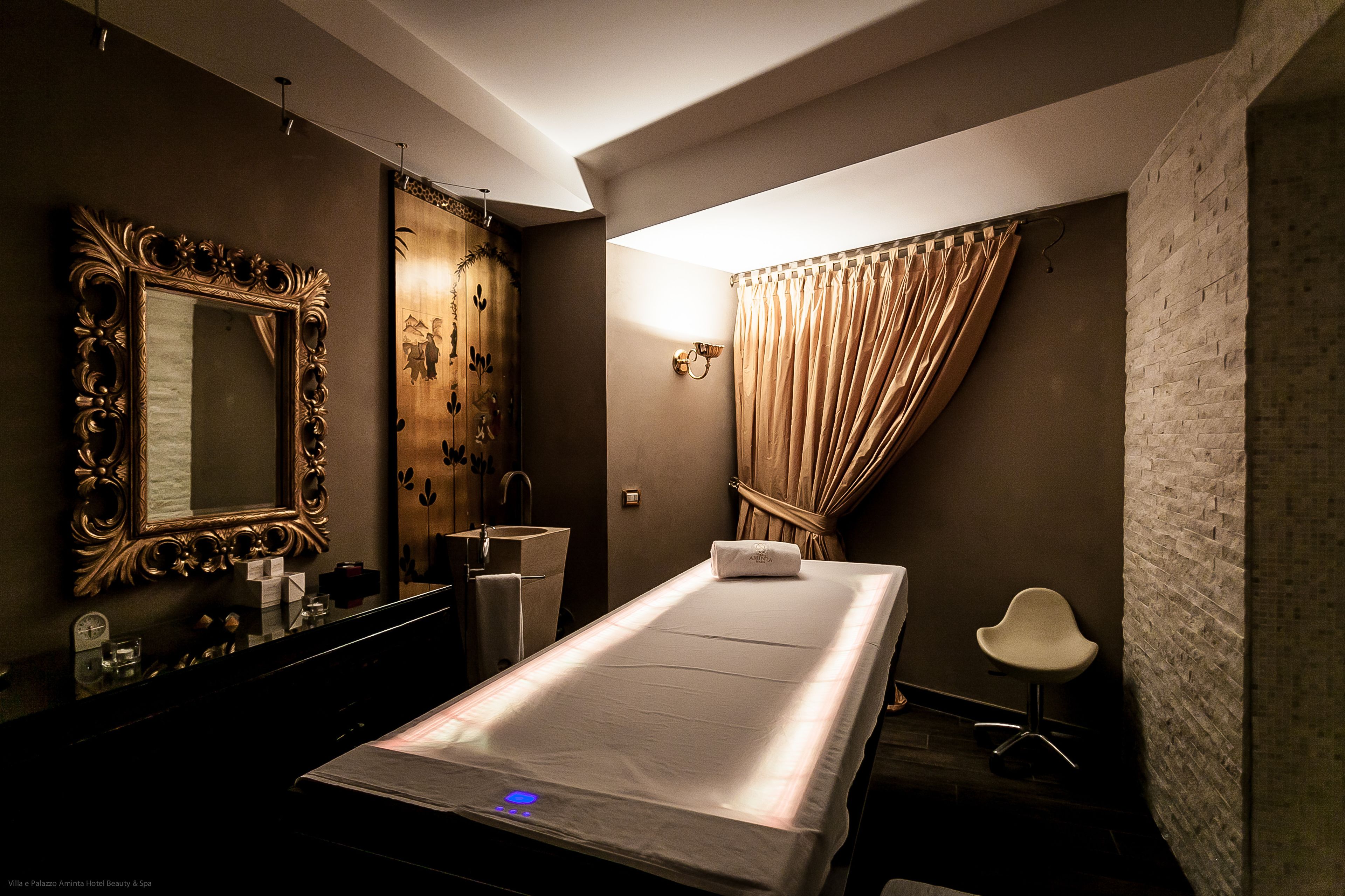 Une pièce comprenant un lit, une coiffeuse avec un miroir, un lavabo et une chaise.