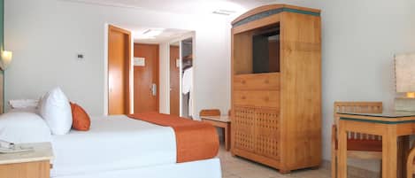 Une chambre d’hôtel avec un lit, une armoire en bois, un bureau et une chaise.
