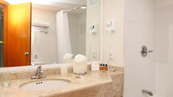 Un baño con lavamanos, espejo y ducha.