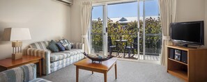 Apartment, 1 Bedroom | Living area | 50-inch TV with cable channels