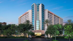 A modern hotel with a curved facade, large glass windows, and a prominent 'Marriott Suites' sign. - Anaheim Marriott Suites (Garden Grove)