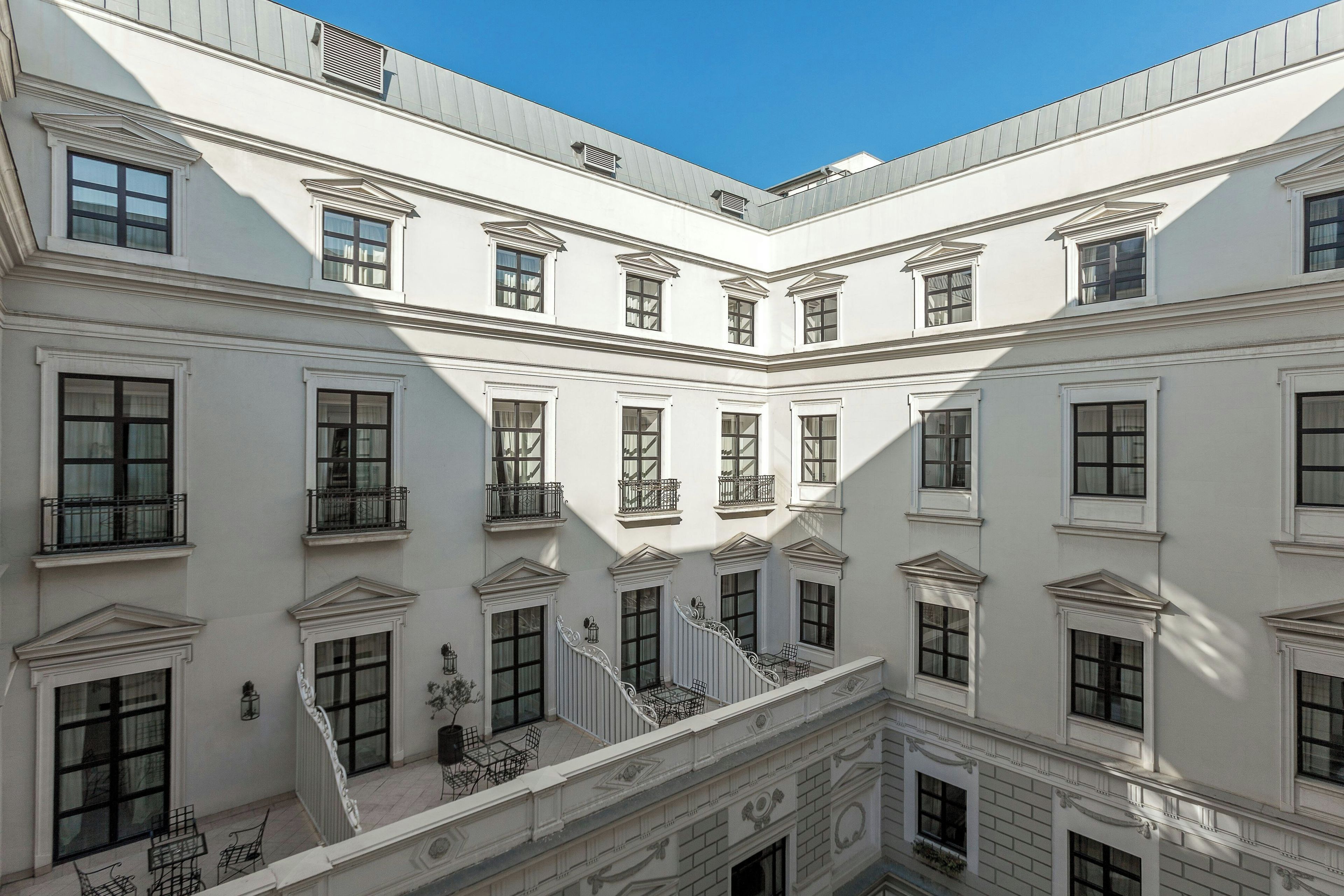 Un immeuble à plusieurs étages, doté d’une façade symétrique, de nombreuses fenêtres et de balcons.