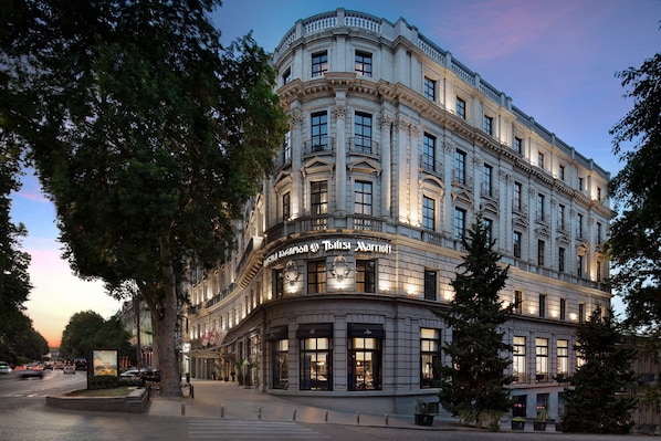A historic building with a curved facade, large windows, and a sign for 'Hilton Marriott'. - Tbilisi Marriott Hotel (Tbilisi)
