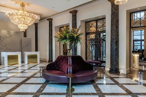 A lobby with a marble floor, a central seating area, and a large chandelier. - Tbilisi Marriott Hotel (Tbilisi)