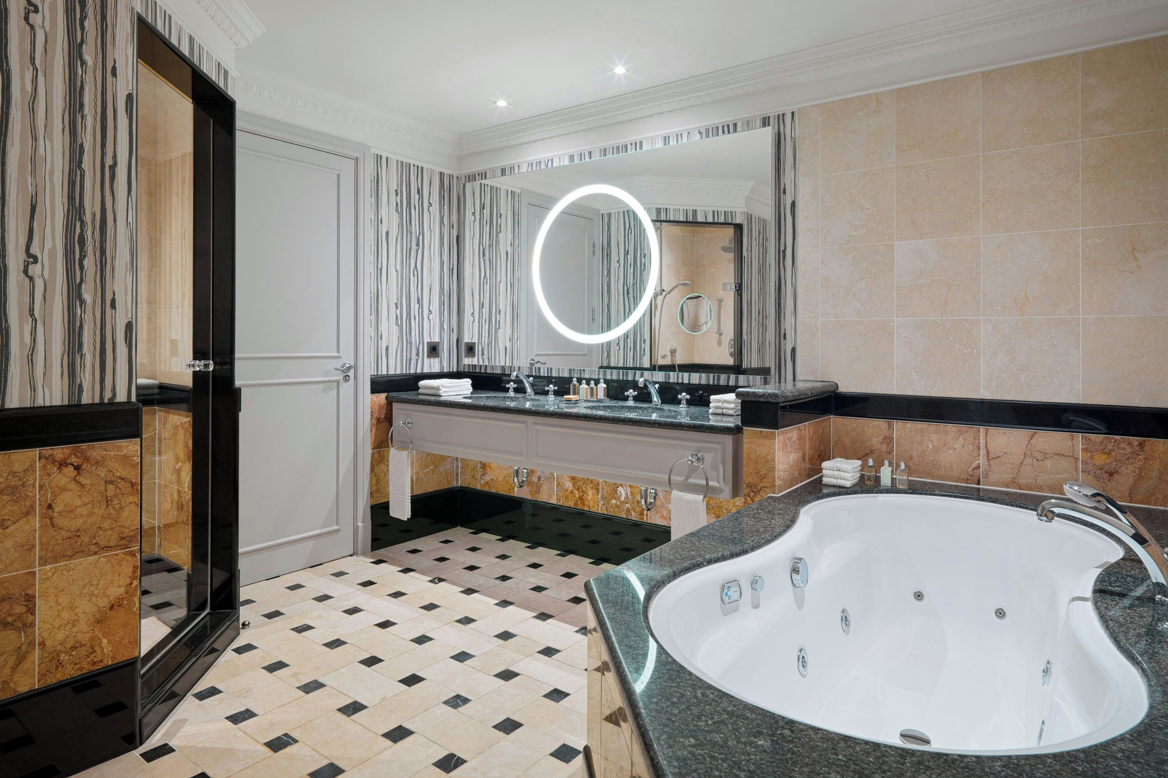 Ein modernes Badezimmer mit einer großen Badewanne, einem Waschtisch mit Spiegel und einer Duschkabine.