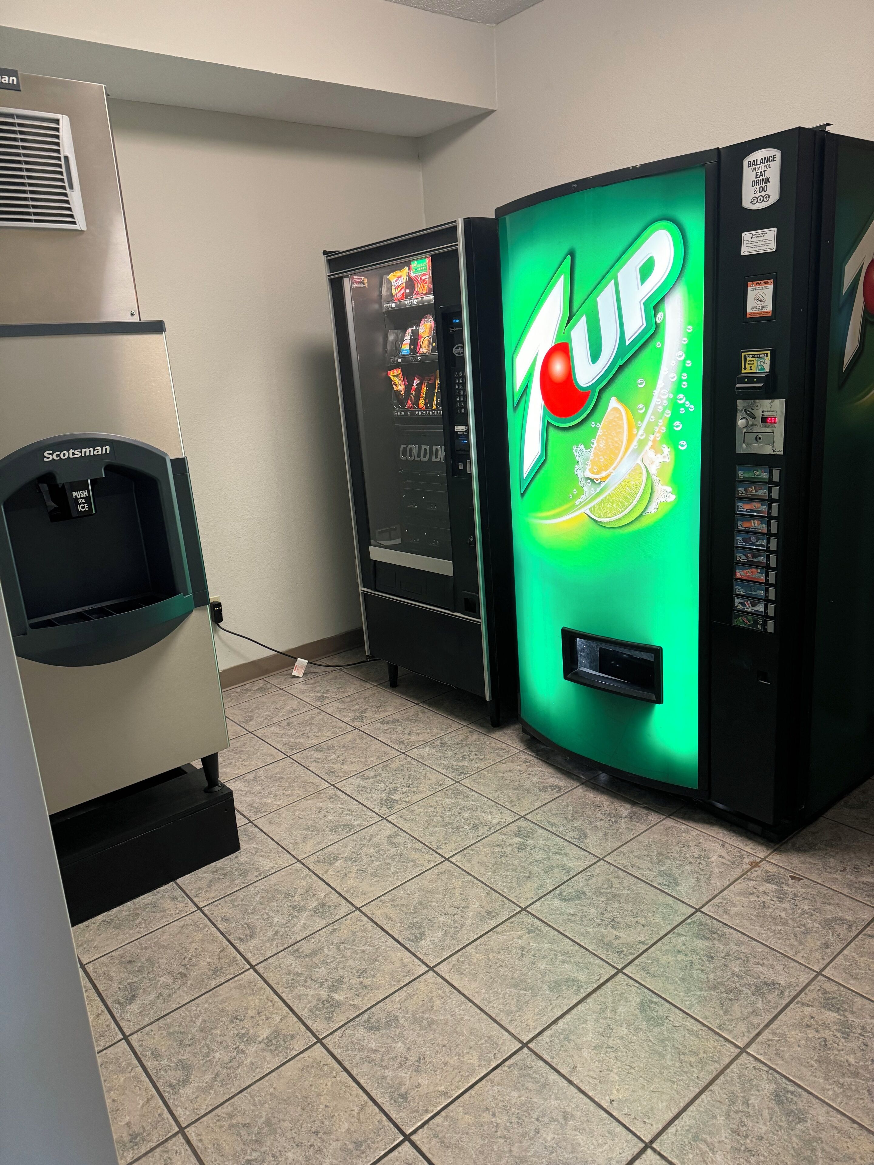 A vending area with a 7UP cooler and a Scotman ice dispenser.