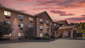 A multi-story brick building with a covered entrance and a parking lot. - Comfort Inn Huntington near University area (Huntington)