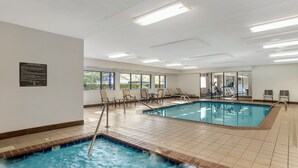 An indoor swimming pool with multiple lanes, lounge chairs, and a hot tub. - Comfort Inn Huntington near University area (Huntington)