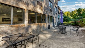 A building with large windows, outdoor seating, and a brick facade. - Comfort Inn Huntington near University area (Huntington)