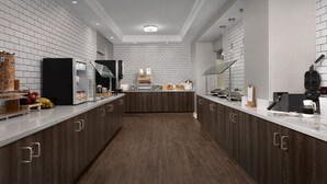 A modern kitchen with white tiled backsplash, dark wooden cabinets, and a central island with a built-in oven and microwave. - Residence Inn by Marriott Charlotte SouthPark (Charlotte)