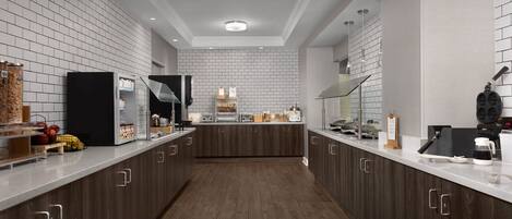 Una cocina moderna con salpicadero de azulejos blancos, armarios de madera oscura e una isla central con horno y microondas integrados.