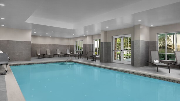 A swimming pool with lounge chairs and a changing room. - Residence Inn by Marriott Charlotte SouthPark (Charlotte)